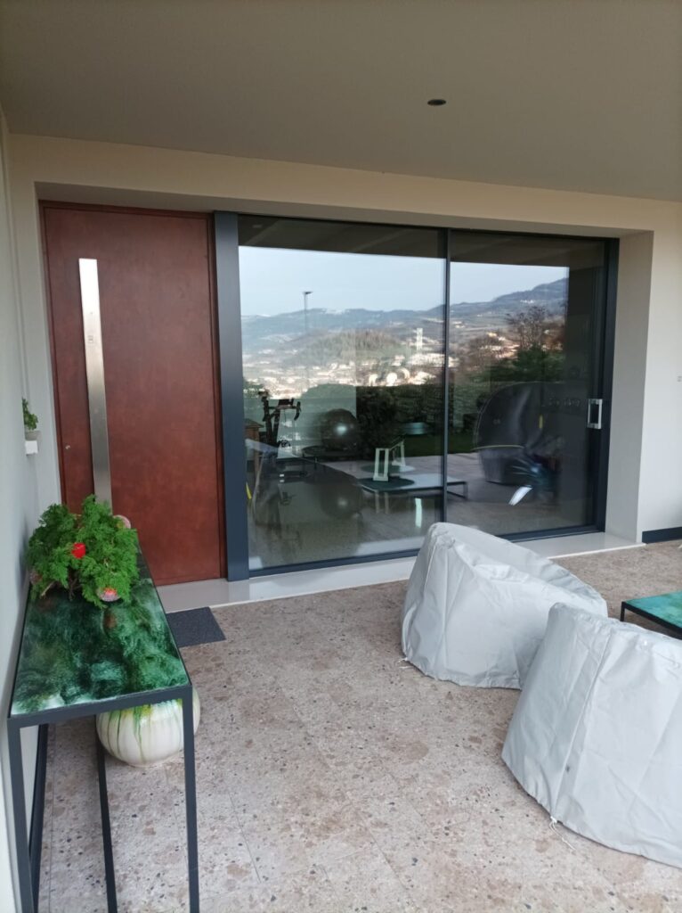 Porta blindata moderna con serramento scorrevole in alluminio minimale a Vicenza - Rosa Serramenti - Design e sicurezza per la tua casa