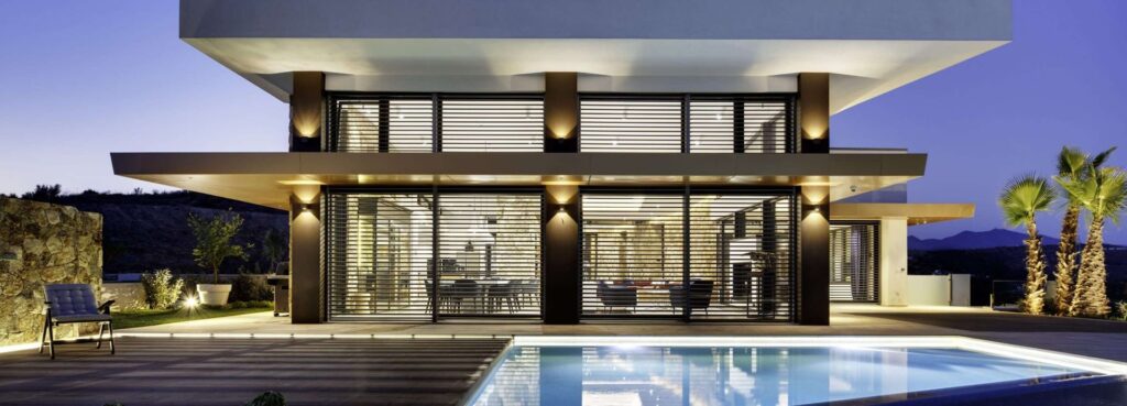 Casa moderna con grandi vetrate in legno-alluminio e piscina, vista serale