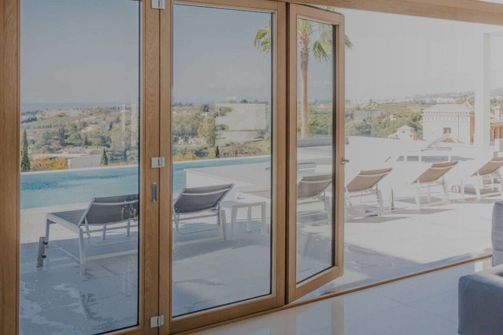 Portafinestra in legno aperta sulla terrazza con piscina