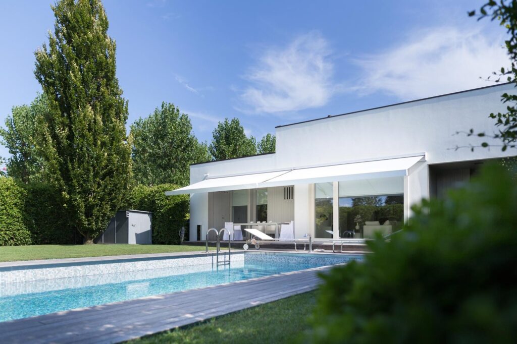 Tende da sole su casa con piscina